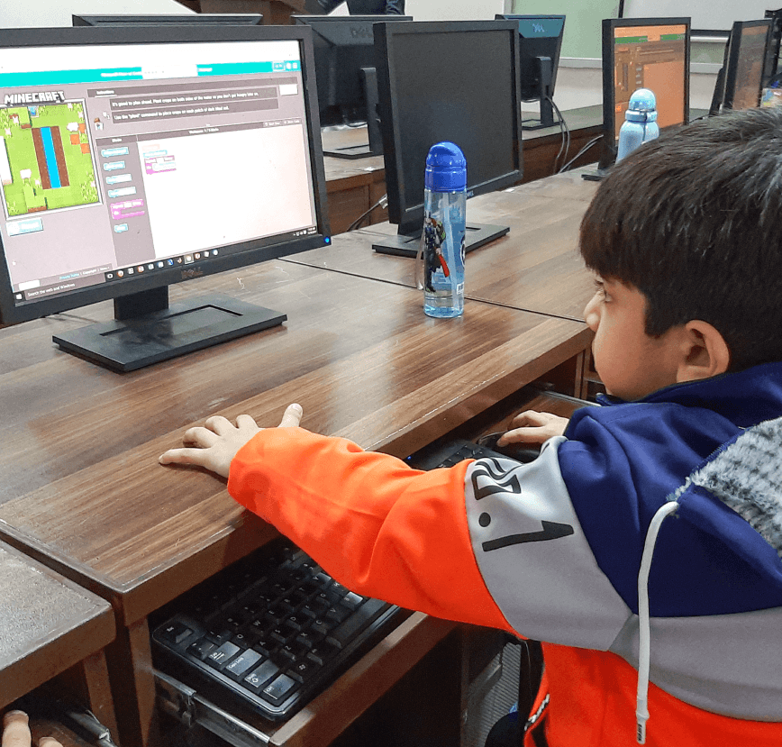 Two children looking at a digital tree with STEAM education icons